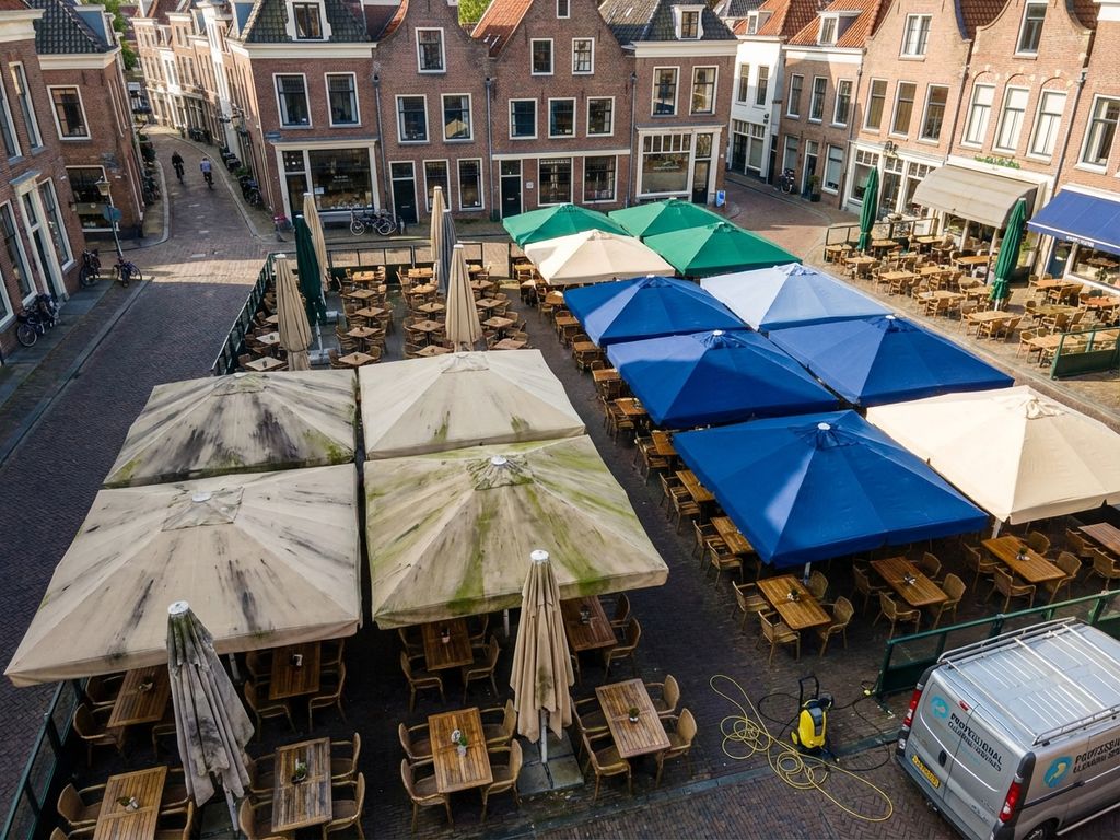 Nederlandse restaurantterras met parasols in verschillende stadia van reiniging, professionele schoonmaakapparatuur zichtbaar