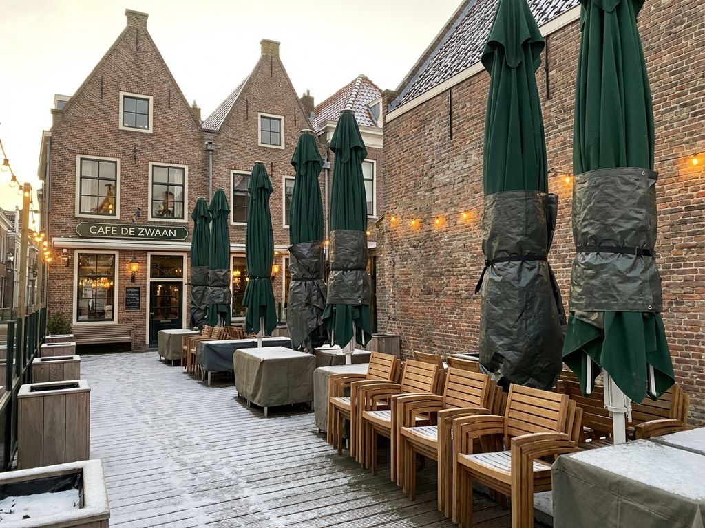 Winterterras van Nederlands restaurant met netjes opgeslagen parasols in beschermhoezen op houten vlonder