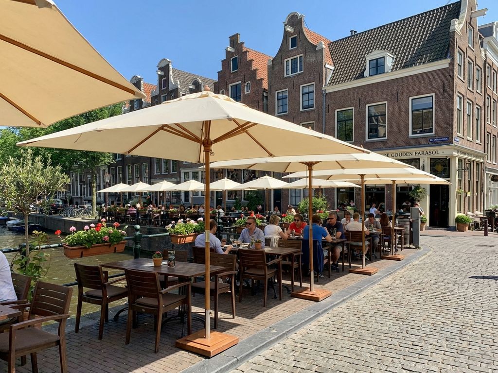 Schone parasols boven houten tafels op restaurant terras in Nederlandse setting met heldere lucht
