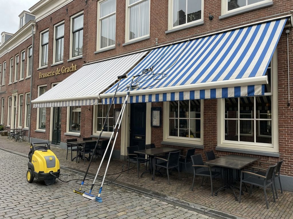 Professionele reiniging van terrasmarkiezen bij Nederlands restaurant met schoonmaakapparatuur op kinderkopjes