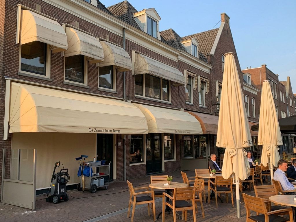 Nederlands restaurantterras met schone markiezen en parasols, omringd door karakteristieke zakelijke architectuur